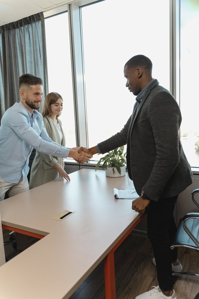 Mastering the First Impression: Your intriguing post title goes here Professional handshake between colleagues in a modern office setting.